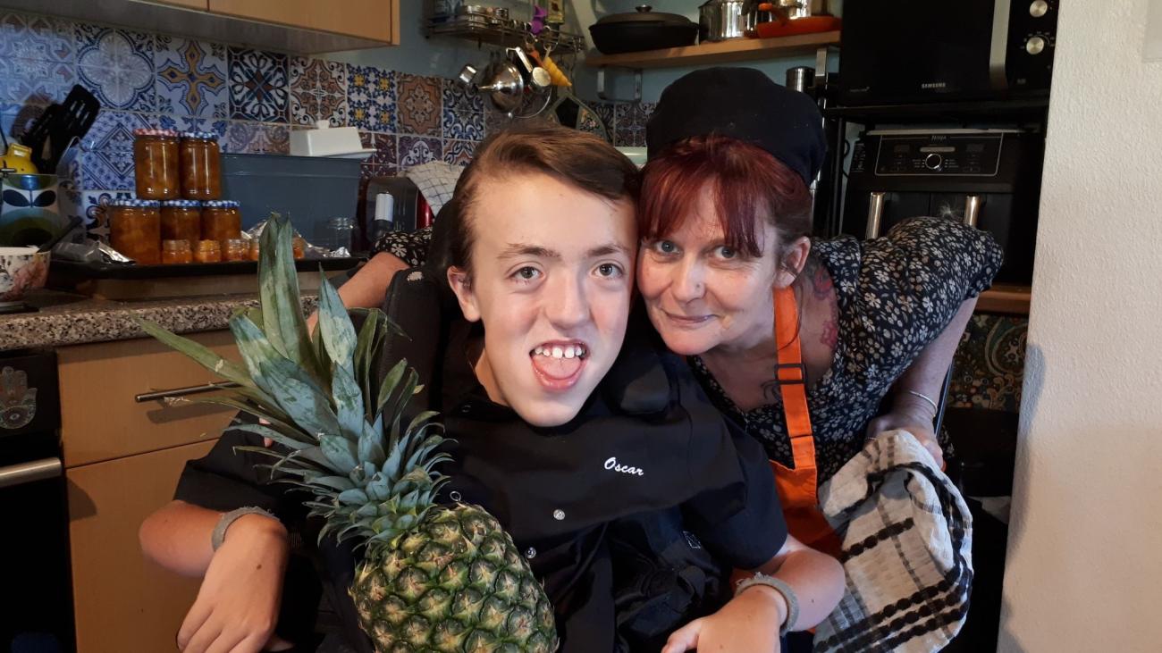 Oscar smiles in his wheelchair with friend Mandy