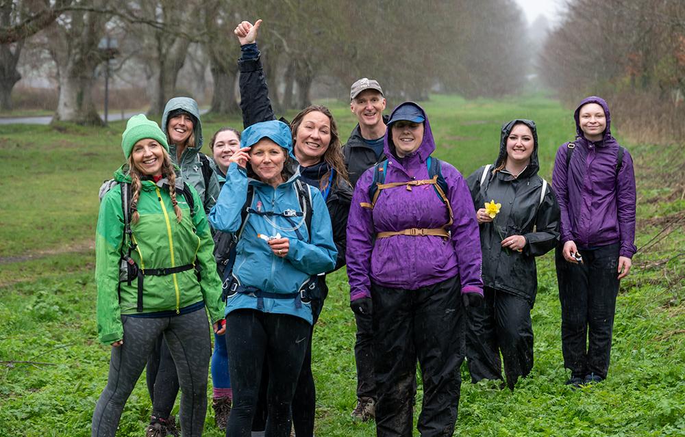 Team Gabby smiling at the camera in a wet and muddy field