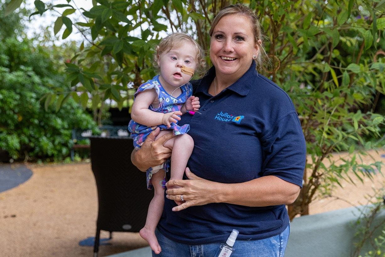 Julia's House Nurse smiling with Scarlett in the hospice garden