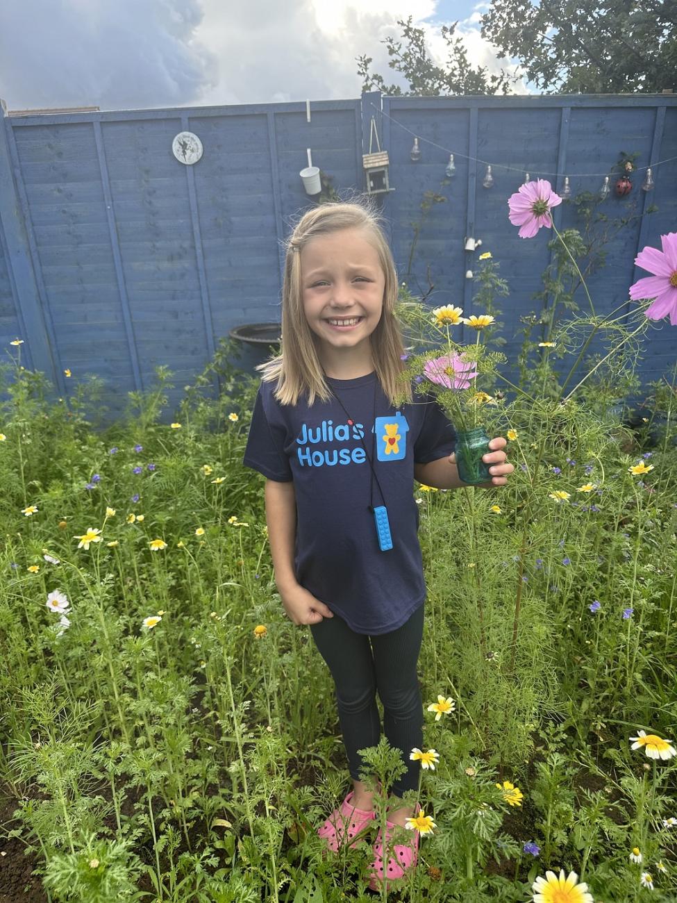 Young fundraiser Romi-Rae stands in her wildflower mini meadow